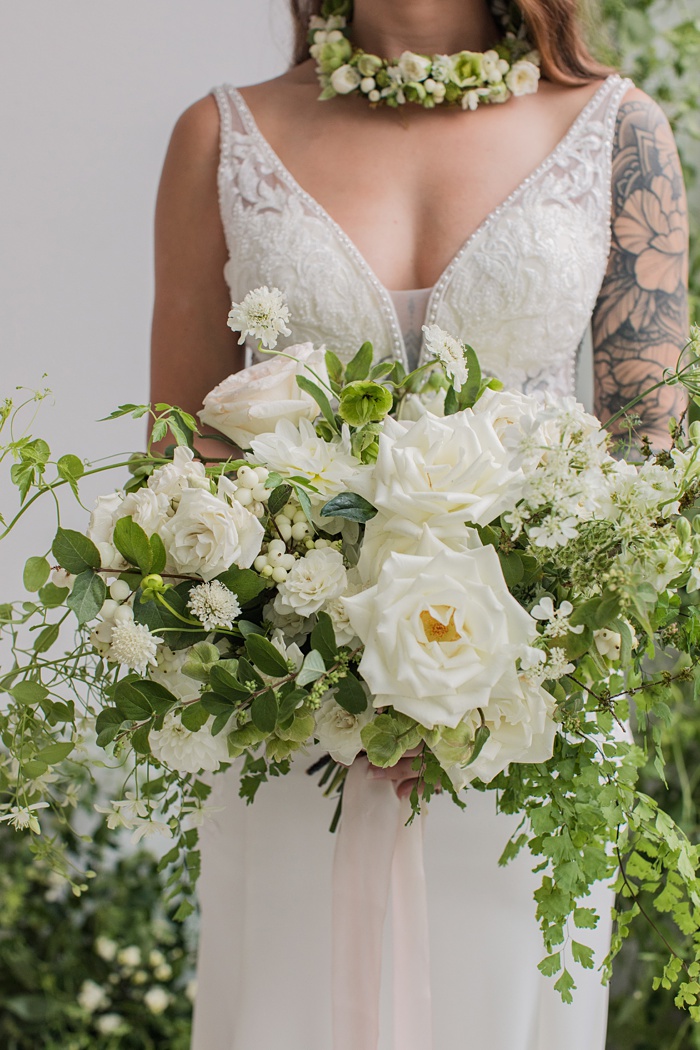 holding the white and green bouquet