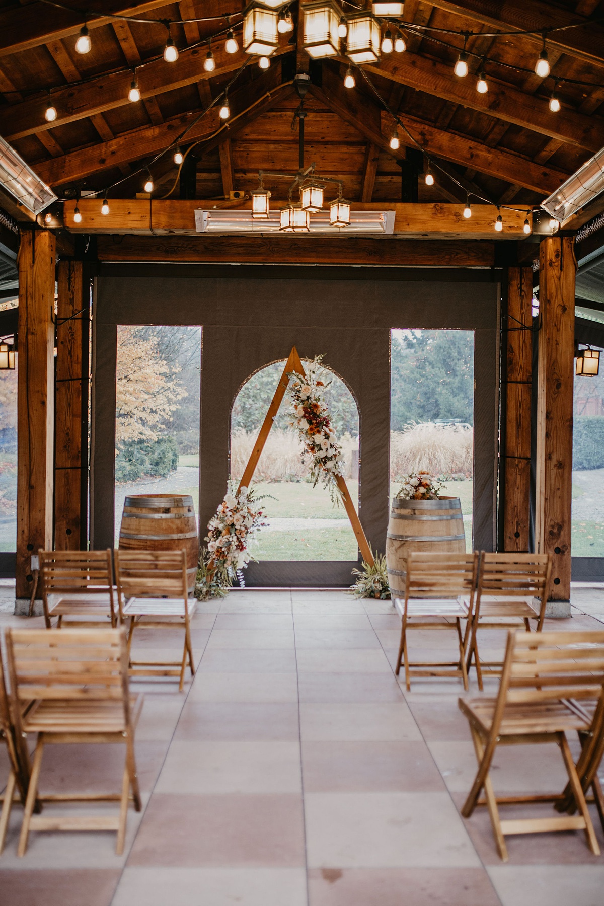 the gorgeous wedding ceremony setup at the Willows Lodge gazebo tent, with triange floral arch